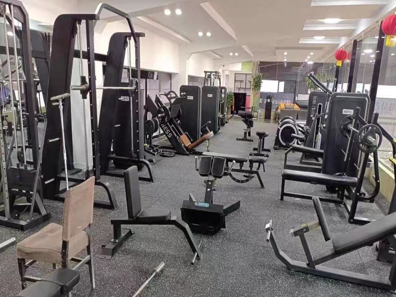 Eine Person misst die Dicke einer schwarzen Gymnastikmatte mit einer Schieblehre.